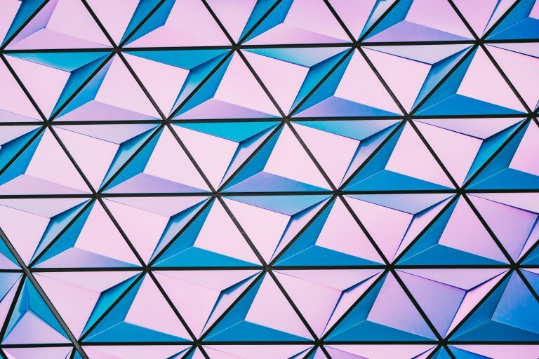 Geometric pattern featuring triangular shapes in shades of pink, purple, and blue, creating a three-dimensional effect, ideal for modern and abstract-themed projects or backgrounds, perfect for a social media planner | plannthat.com
