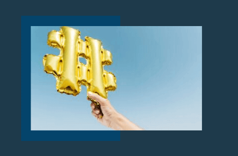 A hand holding a gold hashtag balloon against a clear blue sky background, framed with a dark blue border, creating a modern and clean aesthetic. Ideal for social media or digital marketing content, perfect for a social media planner. | plannthat.com
