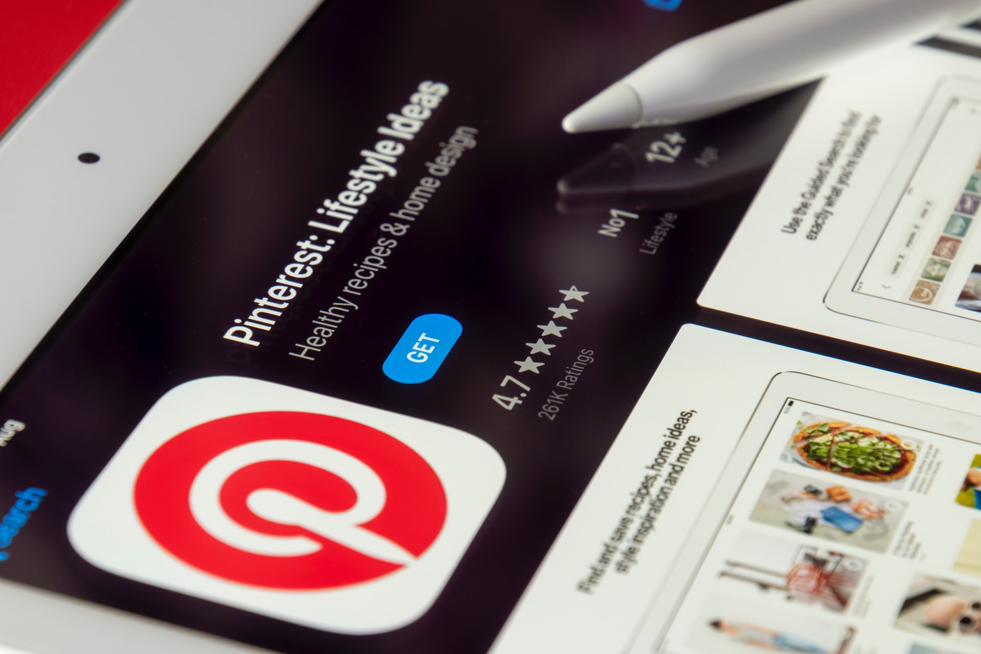 Close-up of a tablet screen displaying the Pinterest app page with a stylus pen, showing a 4.7-star rating and offering lifestyle ideas, ideal for a social media planner | plannthat.com