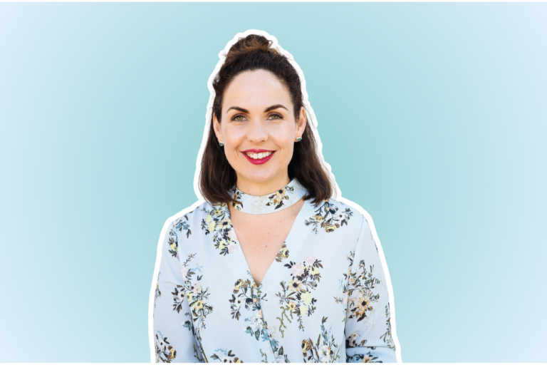 A woman with dark hair in a top knot hairstyle, wearing a floral blouse, smiles against a light blue background with rounded corners, exuding a bright and cheerful tone | Social media planner | plannthat.com