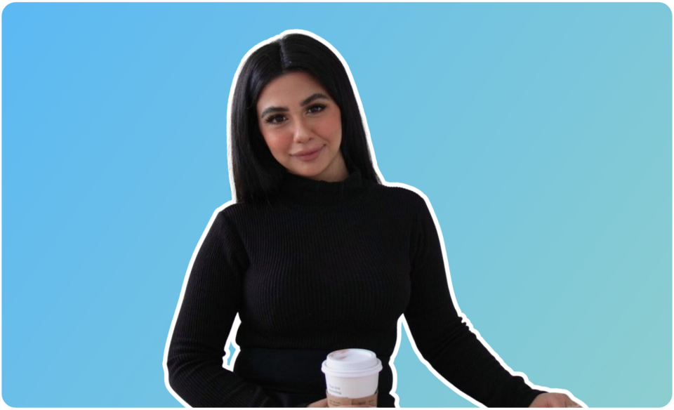 Woman with black hair in a black sweater holding a coffee cup, standing against a gradient blue background, representing a social media planner | plannthat.com