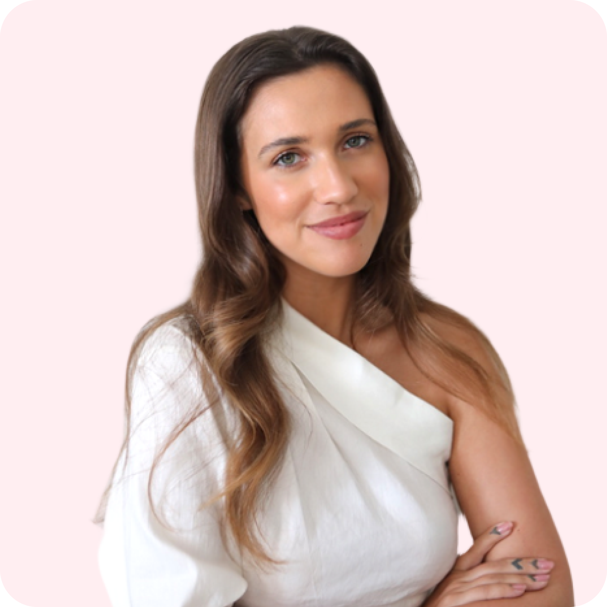 A woman with long, wavy brown hair, wearing a white, off-shoulder top, smiles with her arms crossed against a light pink background, representing a social media scheduler | plannthat.com A woman with long, wavy brown hair, wearing a white, off-shoulder top, smiles with her arms crossed against a light pink background, representing a social media scheduler | plannthat.com
