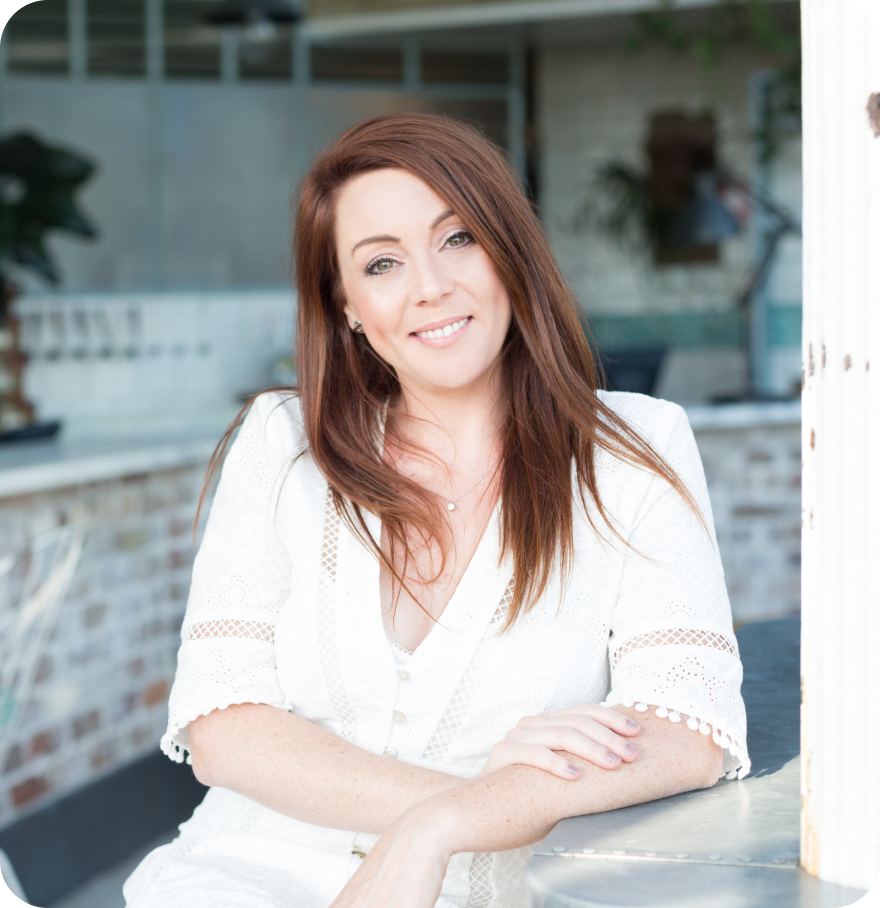 A woman with long brown hair, wearing a white lace top, is smiling and leaning on a counter in a bright, modern setting, showcasing the ease of using a social media scheduler | plannthat.com A woman with long brown hair, wearing a white lace top, is smiling and leaning on a counter in a bright, modern setting, showcasing the ease of using a social media scheduler | plannthat.com